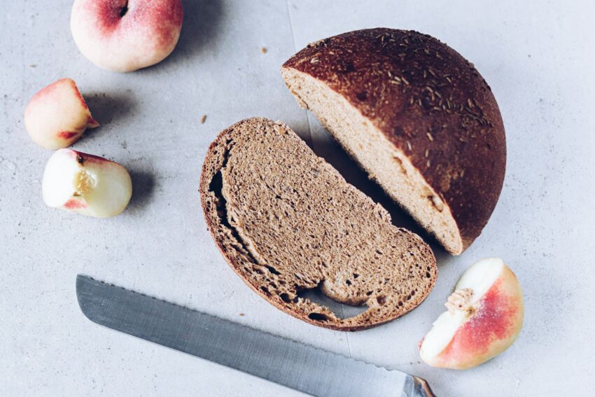 A sliced loaf of bread next to a knife